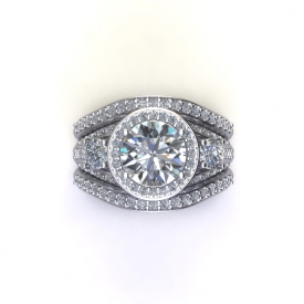 14kt white gold wedding set that has a round brilliant cut center diamond with a halo surrounding it, there are diamonds going down either side and tapering at the bottom of the ring. There are two wedding bands that contour to fit up against the engagement ring, they have shared prong diamonds going across the top of each one.
