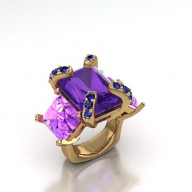 18kt yellow gold three-stone ring with amethyst and pink topaz emerald cut stones, and on the prongs of the amethyst center there are blue sapphires.